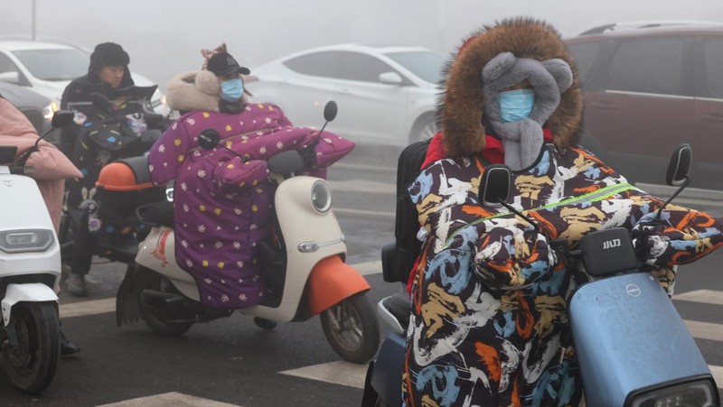 Warga berkendara saat kabut tebal dan udara yang tercemar di Jalan Wenhua Barat di Zaozhuang, Tiongkok, pada 3 Januari 2024.(Photo by Costfoto/NurPhoto via Getty Images)