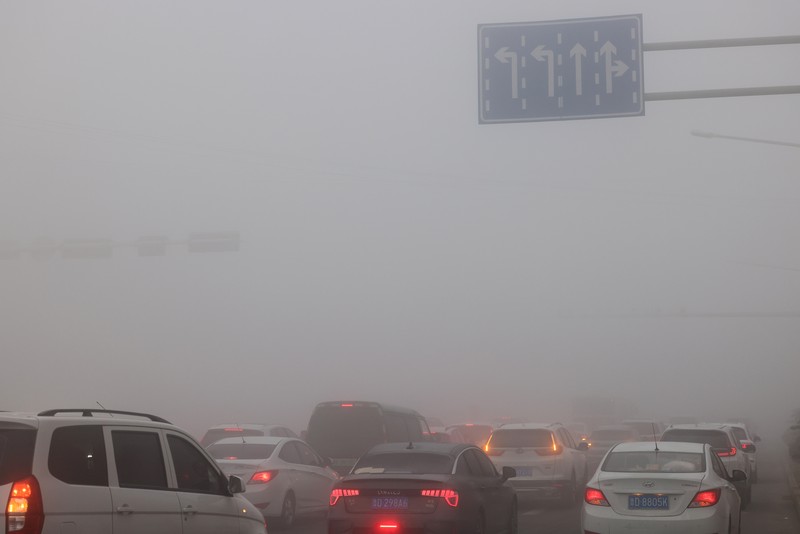 1895745504 Warga berkendara saat kabut tebal dan udara yang tercemar di Jalan Wenhua Barat di Zaozhuang, Tiongkok, pada 3 Januari 2024.(Photo by Costfoto/NurPhoto via Getty Images)