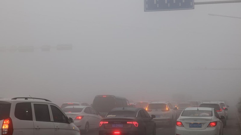Warga berkendara saat kabut tebal dan udara yang tercemar di Jalan Wenhua Barat di Zaozhuang, Tiongkok, pada 3 Januari 2024.(Photo by Costfoto/NurPhoto via Getty Images)