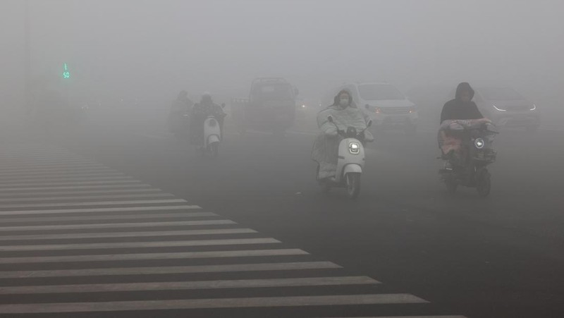 Warga berkendara saat kabut tebal dan udara yang tercemar di Jalan Wenhua Barat di Zaozhuang, Tiongkok, pada 3 Januari 2024.(Photo by Costfoto/NurPhoto via Getty Images)