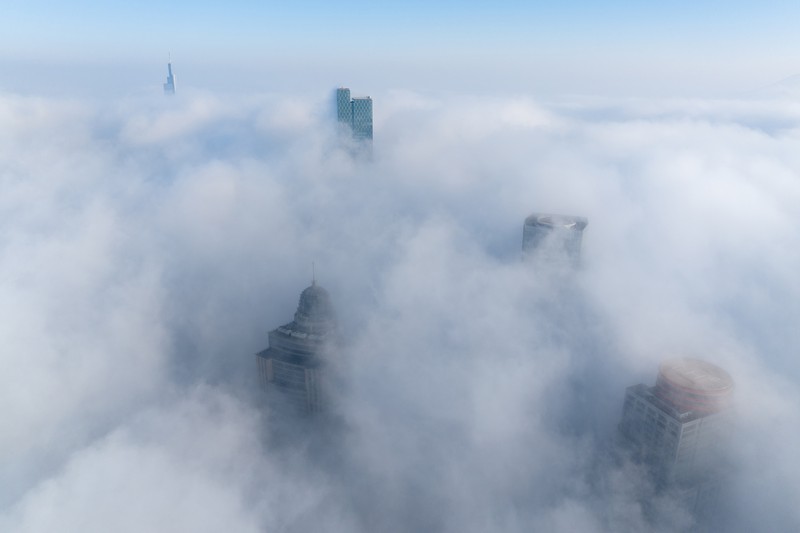 1898128709 NANJING, CHINA - JANUARY 4, 2024 - Aerial photo shows skyscrapers looming in heavy fog in the main urban area of Nanjing, East China's Jiangsu province, Jan 4, 2024. (Photo credit should read CFOTO/Future Publishing via Getty Images)