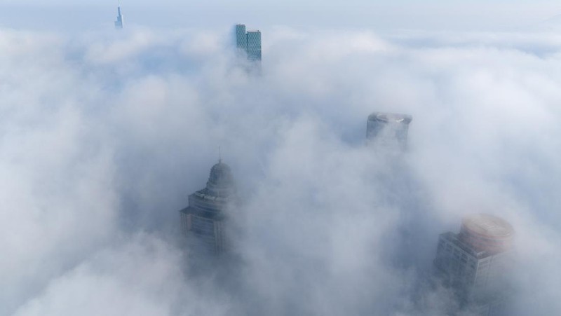 NANJING, CHINA - JANUARY 4, 2024 - Aerial photo shows skyscrapers looming in heavy fog in the main urban area of Nanjing, East China's Jiangsu province, Jan 4, 2024. (Photo credit should read CFOTO/Future Publishing via Getty Images)