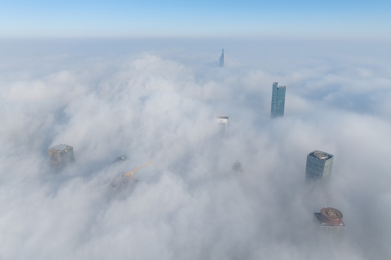 1898128709 NANJING, CHINA - JANUARY 4, 2024 - Aerial photo shows skyscrapers looming in heavy fog in the main urban area of Nanjing, East China's Jiangsu province, Jan 4, 2024. (Photo credit should read CFOTO/Future Publishing via Getty Images)