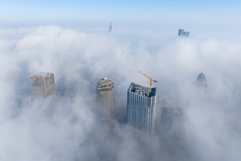 1898128709 NANJING, CHINA - JANUARY 4, 2024 - Aerial photo shows skyscrapers looming in heavy fog in the main urban area of Nanjing, East China's Jiangsu province, Jan 4, 2024. (Photo credit should read CFOTO/Future Publishing via Getty Images)