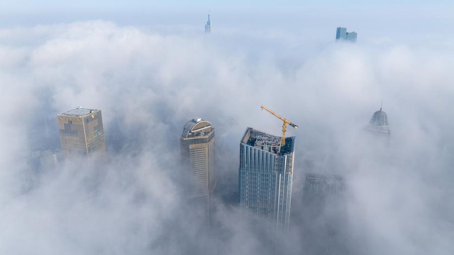 NANJING, CHINA - JANUARY 4, 2024 - Aerial photo shows skyscrapers looming in heavy fog in the main urban area of Nanjing, East China's Jiangsu province, Jan 4, 2024. (Photo credit should read CFOTO/Future Publishing via Getty Images)
