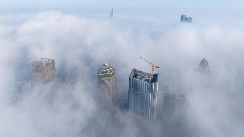 NANJING, CHINA - JANUARY 4, 2024 - Aerial photo shows skyscrapers looming in heavy fog in the main urban area of Nanjing, East China's Jiangsu province, Jan 4, 2024. (Photo credit should read CFOTO/Future Publishing via Getty Images)
