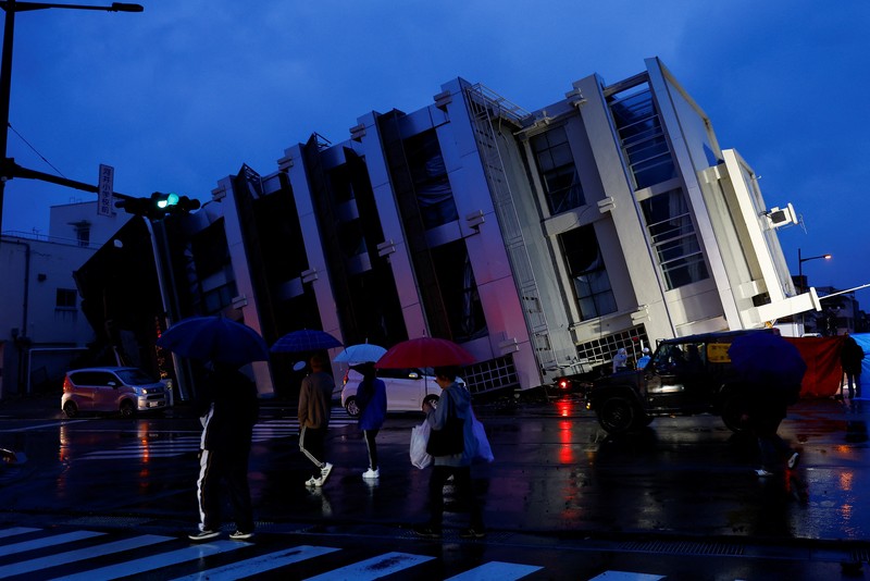 Seorang pria berjalan di sepanjang Jalan Asaichi-dori yang terbakar akibat gempa bumi, di Wajima, Jepang, 4 Januari 2024. (REUTERS/Kim Kyung-Hoon)