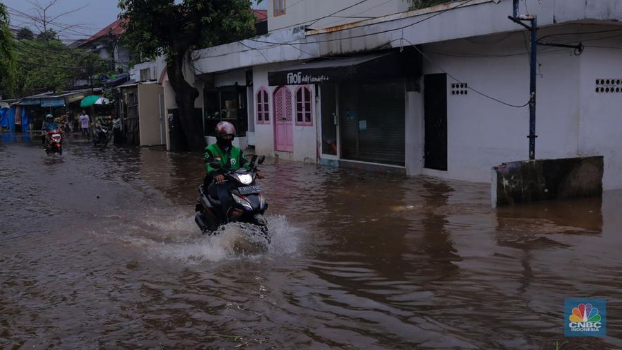 Pekerja membersihkan air pada salah satu toko bunga usai banjir melanda kawasan Kemang, Jakarta, Kamis (4/1/2024). (CNBC Indonesia/Faisal Rahman)