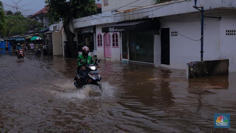 Pekerja membersihkan air pada salah satu toko bunga usai banjir melanda kawasan Kemang, Jakarta, Kamis (4/1/2024). (CNBC Indonesia/Faisal Rahman)