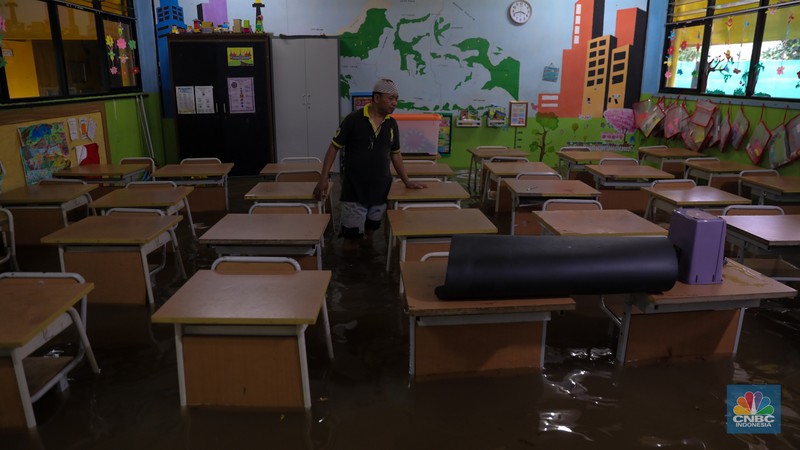 Pekerja membersihkan air pada salah satu toko bunga usai banjir melanda kawasan Kemang, Jakarta, Kamis (4/1/2024). (CNBC Indonesia/Faisal Rahman)