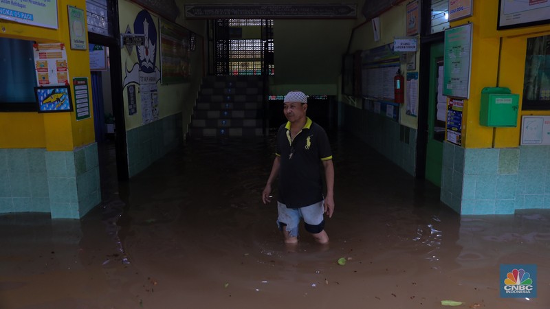 Pekerja membersihkan air pada salah satu toko bunga usai banjir melanda kawasan Kemang, Jakarta, Kamis (4/1/2024). (CNBC Indonesia/Faisal Rahman)