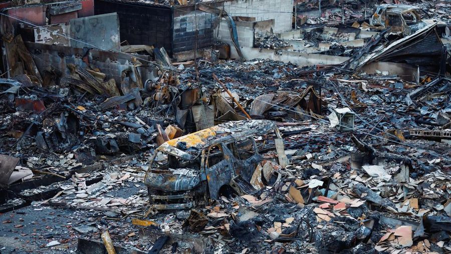 Seorang pria berjalan di sepanjang Jalan Asaichi-dori yang terbakar akibat gempa bumi, di Wajima, Jepang, 4 Januari 2024. (REUTERS/Kim Kyung-Hoon)