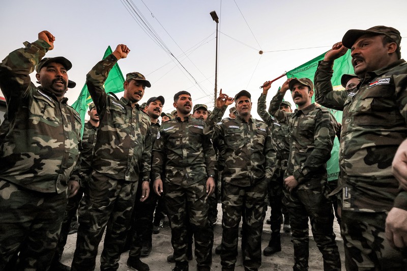 Members of Iraq's Popular Mobilisation Forces (PMF) paramilitaries carry the bodies of two of their slain comrades during their funeral at the PMF headquarters in Baghdad on January 4, 2024. A US strike in Baghdad on January 4 killed a military commander of the PMF, an ex-paramilitary faction of the grouping said, with an Iraqi security official reporting two deaths in a drone attack. Harakat al-Nujaba, one of the PMF's factions, said in a statement that 