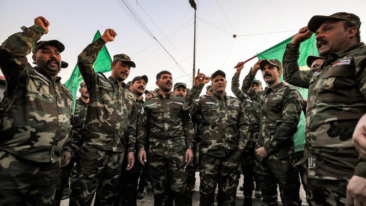 Members of Iraq's Popular Mobilisation Forces (PMF) paramilitaries chant slogans ahead of the funeral of the group's slain members at the PMF headquarters in Baghdad on January 4, 2024. A US strike in Baghdad on January 4 killed a military commander of the PMF, an ex-paramilitary faction of the grouping said, with an Iraqi security official reporting two deaths in a drone attack. Harakat al-Nujaba, one of the PMF's factions, said in a statement that 
