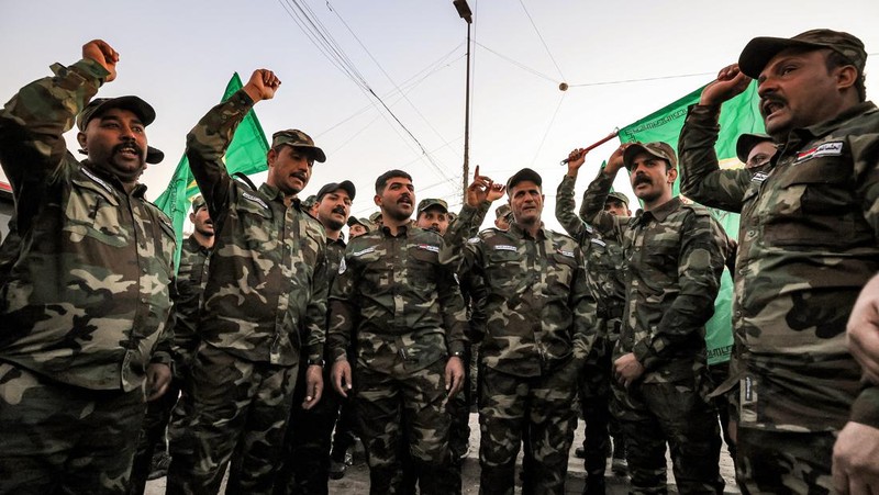 Members of Iraq's Popular Mobilisation Forces (PMF) paramilitaries carry the bodies of two of their slain comrades during their funeral at the PMF headquarters in Baghdad on January 4, 2024. A US strike in Baghdad on January 4 killed a military commander of the PMF, an ex-paramilitary faction of the grouping said, with an Iraqi security official reporting two deaths in a drone attack. Harakat al-Nujaba, one of the PMF's factions, said in a statement that 