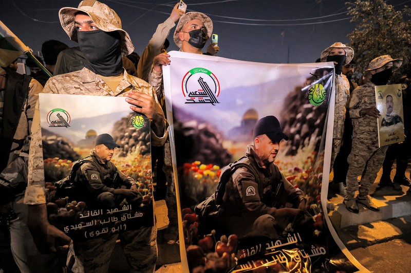 Members of Iraq's Popular Mobilisation Forces (PMF) paramilitaries carry the bodies of two of their slain comrades during their funeral at the PMF headquarters in Baghdad on January 4, 2024. A US strike in Baghdad on January 4 killed a military commander of the PMF, an ex-paramilitary faction of the grouping said, with an Iraqi security official reporting two deaths in a drone attack. Harakat al-Nujaba, one of the PMF's factions, said in a statement that 