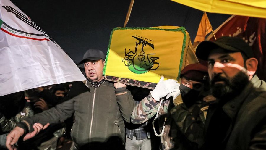 Members of Iraq's Popular Mobilisation Forces (PMF) paramilitaries carry the body of one of their slain comrades during the funeral at the PMF headquarters in Baghdad on January 4, 2024. A US strike in Baghdad on January 4 killed a military commander of the PMF, an ex-paramilitary faction of the grouping said, with an Iraqi security official reporting two deaths in a drone attack. Harakat al-Nujaba, one of the PMF's factions, said in a statement that 