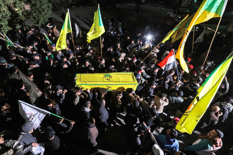 Members of Iraq's Popular Mobilisation Forces (PMF) paramilitaries carry the bodies of two of their slain comrades during their funeral at the PMF headquarters in Baghdad on January 4, 2024. A US strike in Baghdad on January 4 killed a military commander of the PMF, an ex-paramilitary faction of the grouping said, with an Iraqi security official reporting two deaths in a drone attack. Harakat al-Nujaba, one of the PMF's factions, said in a statement that 
