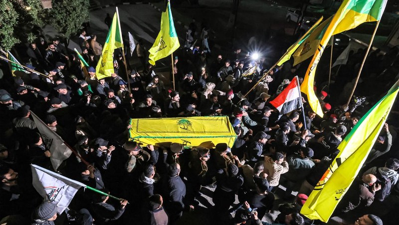 Members of Iraq's Popular Mobilisation Forces (PMF) paramilitaries carry the bodies of two of their slain comrades during their funeral at the PMF headquarters in Baghdad on January 4, 2024. A US strike in Baghdad on January 4 killed a military commander of the PMF, an ex-paramilitary faction of the grouping said, with an Iraqi security official reporting two deaths in a drone attack. Harakat al-Nujaba, one of the PMF's factions, said in a statement that 
