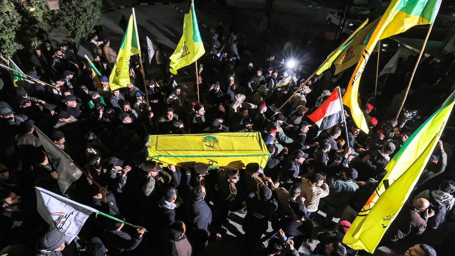 Members of Iraq's Popular Mobilisation Forces (PMF) paramilitaries carry the bodies of two of their slain comrades during their funeral at the PMF headquarters in Baghdad on January 4, 2024. A US strike in Baghdad on January 4 killed a military commander of the PMF, an ex-paramilitary faction of the grouping said, with an Iraqi security official reporting two deaths in a drone attack. Harakat al-Nujaba, one of the PMF's factions, said in a statement that