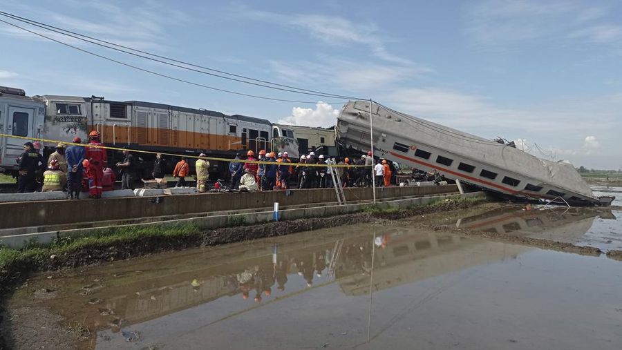 Rescuers inspect the wreckage of trains after a collision in Cicalengka, West Java, Indonesia, Friday, Jan. 5, 2024. The two trains collided on Indonesia's main island of Java on Friday, causing several carriages to buckle and overturn and killing a number of people, officials said. (AP Photo/Abdan Syakura)