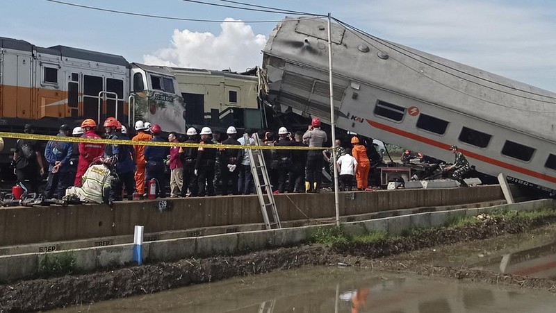 Rescuers inspect the wreckage of trains after a collision in Cicalengka, West Java, Indonesia, Friday, Jan. 5, 2024. The two trains collided on Indonesia's main island of Java on Friday, causing several carriages to buckle and overturn and killing a number of people, officials said. (AP Photo/Abdan Syakura)