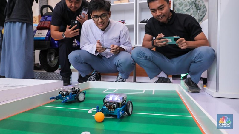Siswa Madrasah Aliyah Negeri (MAN) 9 Jakarta mengoperasikan Soccer Robot saat acara Devotion Experience (Dev-X) di Jakarta Convention Center (JCC), Senayan Jakarta, Jumat (5/1/2024). (CNBC Indonesia/Faisal Rahman)