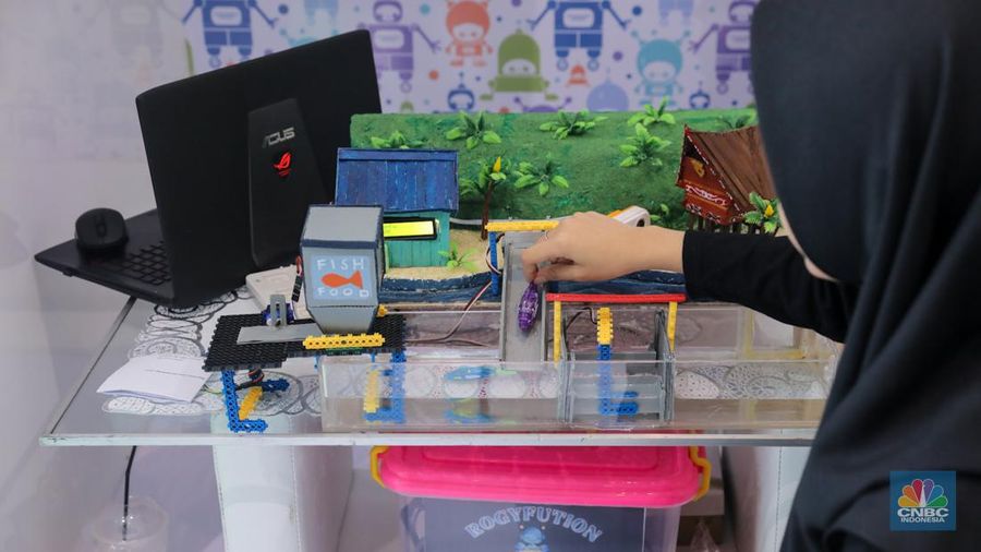 Siswa Madrasah Aliyah Negeri (MAN) 9 Jakarta mengoperasikan Soccer Robot saat acara Devotion Experience (Dev-X) di Jakarta Convention Center (JCC), Senayan Jakarta, Jumat (5/1/2024). (CNBC Indonesia/Faisal Rahman)