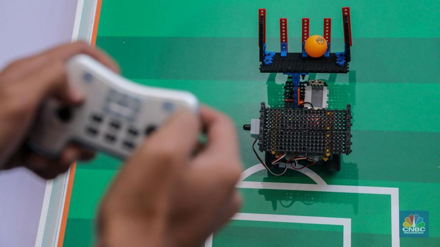 Siswa Madrasah Aliyah Negeri (MAN) 9 Jakarta mengoperasikan Soccer Robot saat acara Devotion Experience (Dev-X) di Jakarta Convention Center (JCC), Senayan Jakarta, Jumat (5/1/2024). (CNBC Indonesia/Faisal Rahman)