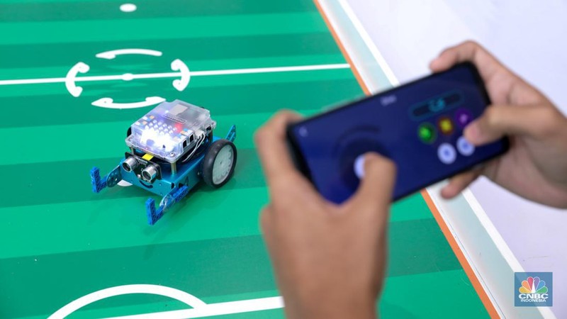 Siswa Madrasah Aliyah Negeri (MAN) 9 Jakarta mengoperasikan Soccer Robot saat acara Devotion Experience (Dev-X) di Jakarta Convention Center (JCC), Senayan Jakarta, Jumat (5/1/2024). (CNBC Indonesia/Faisal Rahman)