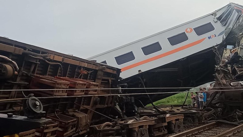 Tim penyelamat berjalan di dekat puing-puing kereta api setelah tabrakan di Cicalengka, Jawa Barat, Indonesia, Jumat, 5 Januari 2024. Kedua kereta itu bertabrakan di pulau utama Indonesia, Jawa, pada hari Jumat, menyebabkan beberapa gerbong tertekuk dan terbalik. (AP Photo/Abdan Syakura)