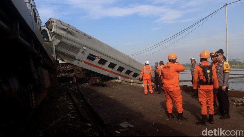 Indonesia Train Crash Tim penyelamat berjalan di dekat puing-puing kereta api setelah tabrakan di Cicalengka, Jawa Barat, Indonesia, Jumat, 5 Januari 2024. Kedua kereta itu bertabrakan di pulau utama Indonesia, Jawa, pada hari Jumat, menyebabkan beberapa gerbong tertekuk dan terbalik. (AP Photo/Abdan Syakura)