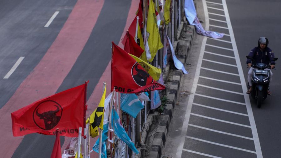 Kendaraan melintas di dekat bendera Partai Politik yang terpasang pada pembatas jalan di Jakarta, Senin (8/1/2023). (CNBC Indonesia/Faisal Rahman)