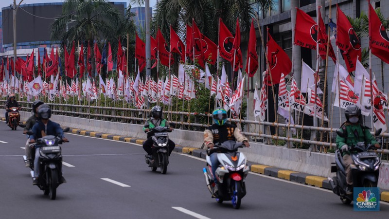 Kendaraan melintas di dekat bendera Partai Politik yang terpasang pada pembatas jalan di Jakarta, Senin (8/1/2023). Kendaraan melintas di dekat bendera Partai Politik yang terpasang pada pembatas jalan di Jakarta, Senin (8/1/2023). (CNBC Indonesia/Faisal Rahman)