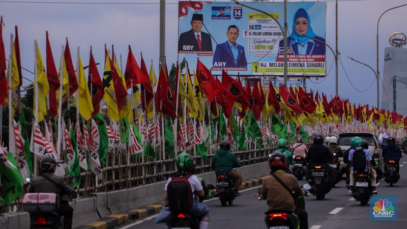 Kendaraan melintas di dekat bendera Partai Politik yang terpasang pada pembatas jalan di Jakarta, Senin (8/1/2023). Kendaraan melintas di dekat bendera Partai Politik yang terpasang pada pembatas jalan di Jakarta, Senin (8/1/2023). (CNBC Indonesia/Faisal Rahman)