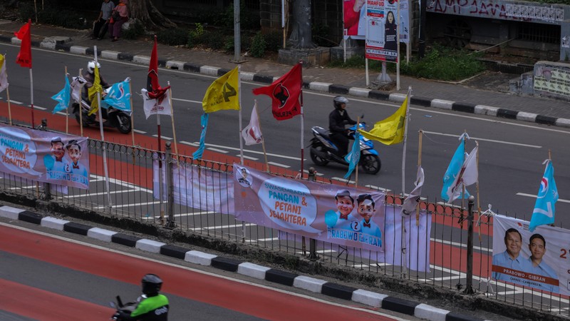 Kendaraan melintas di dekat bendera Partai Politik yang terpasang pada pembatas jalan di Jakarta, Senin (8/1/2023). Kendaraan melintas di dekat bendera Partai Politik yang terpasang pada pembatas jalan di Jakarta, Senin (8/1/2023). (CNBC Indonesia/Faisal Rahman)