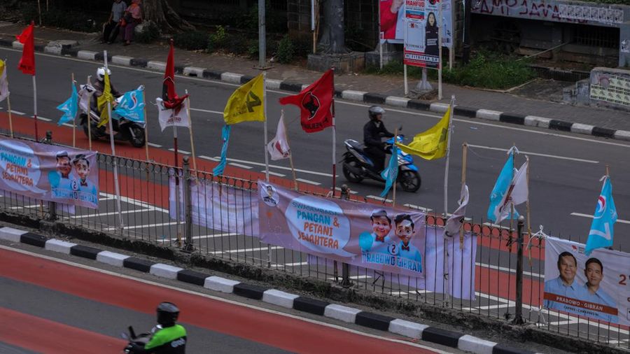 Kendaraan melintas di dekat bendera Partai Politik yang terpasang pada pembatas jalan di Jakarta, Senin (8/1/2023). (CNBC Indonesia/Faisal Rahman)