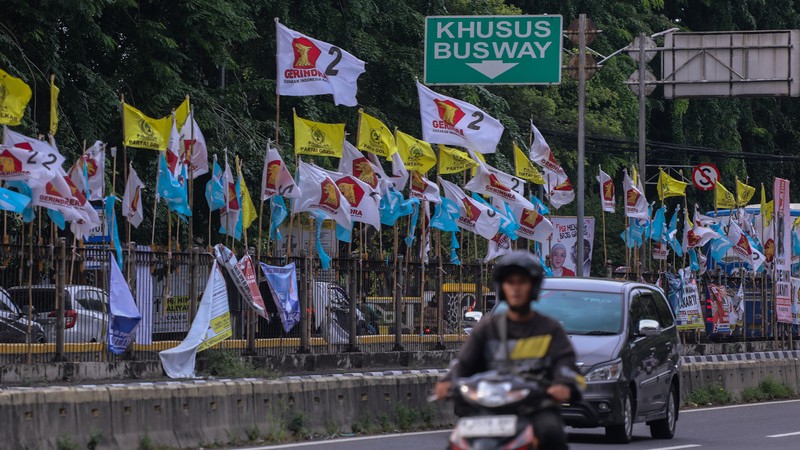 Kendaraan melintas di dekat bendera Partai Politik yang terpasang pada pembatas jalan di Jakarta, Senin (8/1/2023). Kendaraan melintas di dekat bendera Partai Politik yang terpasang pada pembatas jalan di Jakarta, Senin (8/1/2023). (CNBC Indonesia/Faisal Rahman)