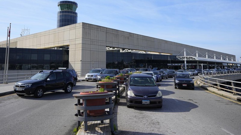 Wisatawan mendorong barang bawaan mereka di terminal keberangkatan Bandara Internasional Rafik Hariri di Beirut, Lebanon, Senin, 8 Januari 2024. Layar tampilan informasi pada hari Minggu di bandara internasional Beirut diretas oleh kelompok anti-Hizbullah domestik, saat bentrokan antara Kelompok militan Lebanon dan militer Israel terus menguat di sepanjang perbatasan. Informasi keberangkatan dan kedatangan pada hari Minggu digantikan oleh pesan yang menuduh kelompok Hizbullah menempatkan Lebanon dalam risiko perang habis-habisan dengan Israel. (AP Photo/Bilal Hussein)