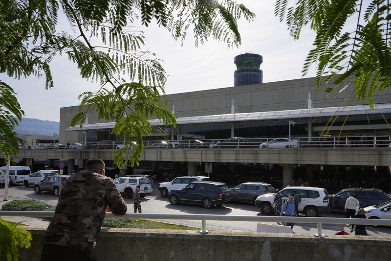Wisatawan mendorong barang bawaan mereka di terminal keberangkatan Bandara Internasional Rafik Hariri di Beirut, Lebanon, Senin, 8 Januari 2024. Layar tampilan informasi pada hari Minggu di bandara internasional Beirut diretas oleh kelompok anti-Hizbullah domestik, saat bentrokan antara Kelompok militan Lebanon dan militer Israel terus menguat di sepanjang perbatasan. Informasi keberangkatan dan kedatangan pada hari Minggu digantikan oleh pesan yang menuduh kelompok Hizbullah menempatkan Lebanon dalam risiko perang habis-habisan dengan Israel. (AP Photo/Bilal Hussein)