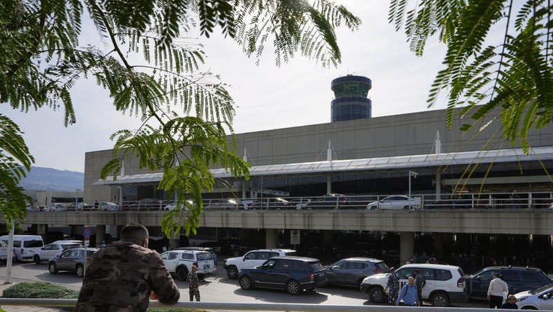 Wisatawan mendorong barang bawaan mereka di terminal keberangkatan Bandara Internasional Rafik Hariri di Beirut, Lebanon, Senin, 8 Januari 2024. Layar tampilan informasi pada hari Minggu di bandara internasional Beirut diretas oleh kelompok anti-Hizbullah domestik, saat bentrokan antara Kelompok militan Lebanon dan militer Israel terus menguat di sepanjang perbatasan. Informasi keberangkatan dan kedatangan pada hari Minggu digantikan oleh pesan yang menuduh kelompok Hizbullah menempatkan Lebanon dalam risiko perang habis-habisan dengan Israel. (AP Photo/Bilal Hussein)