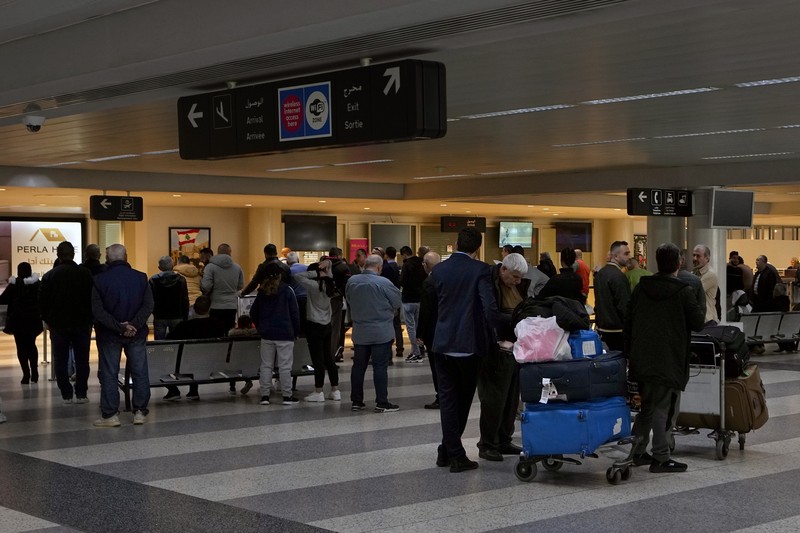 Wisatawan mendorong barang bawaan mereka di terminal keberangkatan Bandara Internasional Rafik Hariri di Beirut, Lebanon, Senin, 8 Januari 2024. Layar tampilan informasi pada hari Minggu di bandara internasional Beirut diretas oleh kelompok anti-Hizbullah domestik, saat bentrokan antara Kelompok militan Lebanon dan militer Israel terus menguat di sepanjang perbatasan. Informasi keberangkatan dan kedatangan pada hari Minggu digantikan oleh pesan yang menuduh kelompok Hizbullah menempatkan Lebanon dalam risiko perang habis-habisan dengan Israel. (AP Photo/Bilal Hussein)