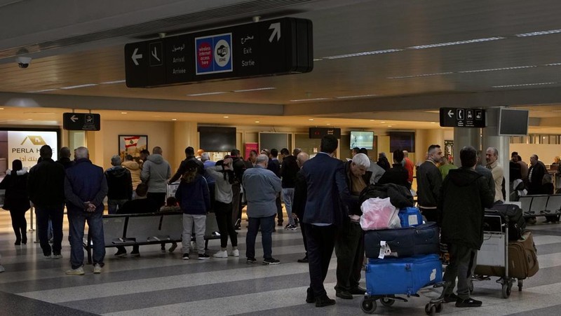 Wisatawan mendorong barang bawaan mereka di terminal keberangkatan Bandara Internasional Rafik Hariri di Beirut, Lebanon, Senin, 8 Januari 2024. Layar tampilan informasi pada hari Minggu di bandara internasional Beirut diretas oleh kelompok anti-Hizbullah domestik, saat bentrokan antara Kelompok militan Lebanon dan militer Israel terus menguat di sepanjang perbatasan. Informasi keberangkatan dan kedatangan pada hari Minggu digantikan oleh pesan yang menuduh kelompok Hizbullah menempatkan Lebanon dalam risiko perang habis-habisan dengan Israel. (AP Photo/Bilal Hussein)