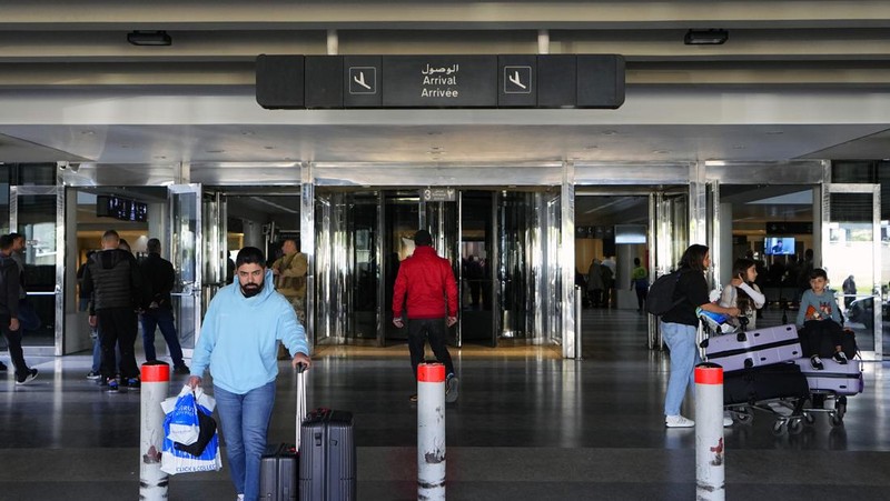 Wisatawan mendorong barang bawaan mereka di terminal keberangkatan Bandara Internasional Rafik Hariri di Beirut, Lebanon, Senin, 8 Januari 2024. Layar tampilan informasi pada hari Minggu di bandara internasional Beirut diretas oleh kelompok anti-Hizbullah domestik, saat bentrokan antara Kelompok militan Lebanon dan militer Israel terus menguat di sepanjang perbatasan. Informasi keberangkatan dan kedatangan pada hari Minggu digantikan oleh pesan yang menuduh kelompok Hizbullah menempatkan Lebanon dalam risiko perang habis-habisan dengan Israel. (AP Photo/Bilal Hussein)