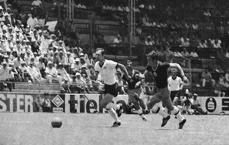 Kapten Belanda Johan Cruyff, kiri, berbicara dengan wasit, disaksikan oleh kapten Jerman Barat Franz Beckenbauer, kanan, sebelum dimulainya pertandingan sepak bola Jerman Barat v Belanda di Munich, Jerman Barat, pada 3 Juli 1984. (AP Photo/Dieter Endlicher)