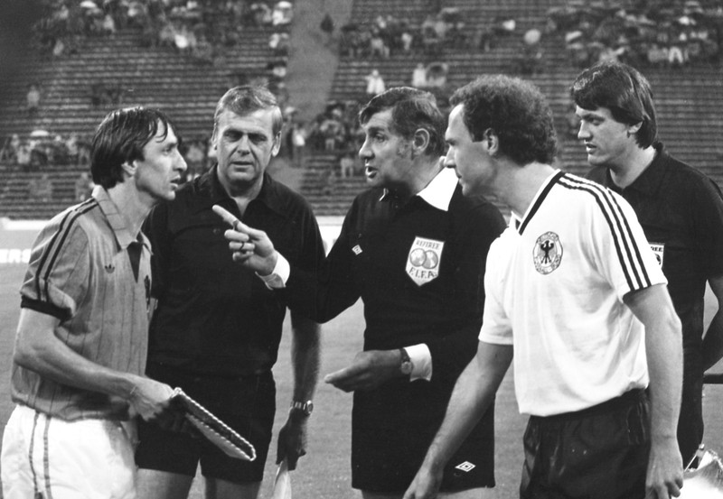 Kapten Belanda Johan Cruyff, kiri, berbicara dengan wasit, disaksikan oleh kapten Jerman Barat Franz Beckenbauer, kanan, sebelum dimulainya pertandingan sepak bola Jerman Barat v Belanda di Munich, Jerman Barat, pada 3 Juli 1984. (AP Photo/Dieter Endlicher)
