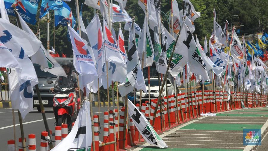 Kendaraan bermotor melintas di samping alat peraga kampanye (APK) pemilu 2024 yang terpasang di pembatas jalur sepeda (stick cone) di kawasan Menteng, Jakarta, Selasa (9/1/2024). Pemasangan APK Pemilu 2024 tersebut melanggar Peraturan KPU yang melarang pemasangan atribut partai atau caleg di fasilitas umum. (CNBC Indonesia/Muhammad Sabki)
