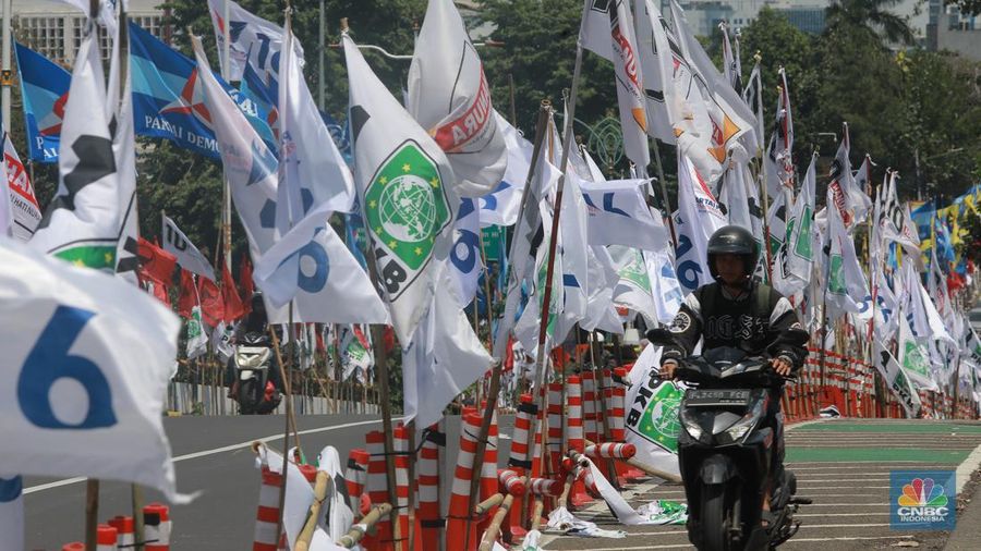 Kendaraan bermotor melintas di samping alat peraga kampanye (APK) pemilu 2024 yang terpasang di pembatas jalur sepeda (stick cone) di kawasan Menteng, Jakarta, Selasa (9/1/2024). Pemasangan APK Pemilu 2024 tersebut melanggar Peraturan KPU yang melarang pemasangan atribut partai atau caleg di fasilitas umum. (CNBC Indonesia/Muhammad Sabki) Kendaraan bermotor melintas di samping alat peraga kampanye (APK) pemilu 2024 yang terpasang di pembatas jalur sepeda (stick cone) di kawasan Menteng, Jakarta, Selasa (9/1/2024). Pemasangan APK Pemilu 2024 tersebut melanggar Peraturan KPU yang melarang pemasangan atribut partai atau caleg di fasilitas umum. (CNBC Indonesia/Muhammad Sabki)