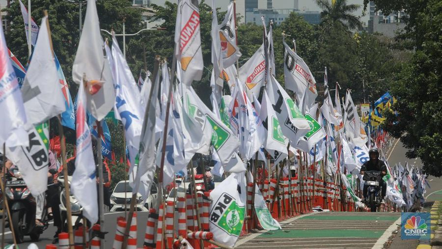 Kendaraan bermotor melintas di samping alat peraga kampanye (APK) pemilu 2024 yang terpasang di pembatas jalur sepeda (stick cone) di kawasan Menteng, Jakarta, Selasa (9/1/2024). Pemasangan APK Pemilu 2024 tersebut melanggar Peraturan KPU yang melarang pemasangan atribut partai atau caleg di fasilitas umum. (²©²ÊÍøÕ¾/Muhammad Sabki)