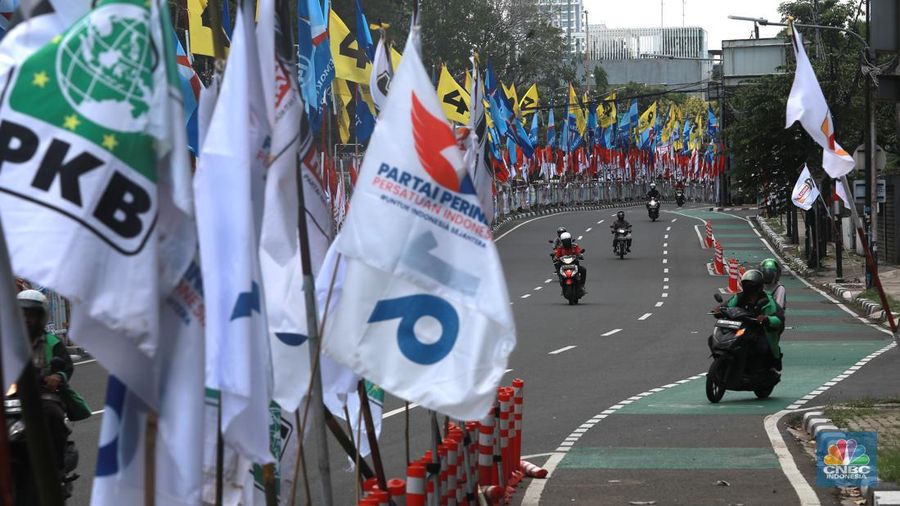 Kendaraan bermotor melintas di samping alat peraga kampanye (APK) pemilu 2024 yang terpasang di pembatas jalur sepeda (stick cone) di kawasan Menteng, Jakarta, Selasa (9/1/2024). Pemasangan APK Pemilu 2024 tersebut melanggar Peraturan KPU yang melarang pemasangan atribut partai atau caleg di fasilitas umum. (CNBC Indonesia/Muhammad Sabki)
